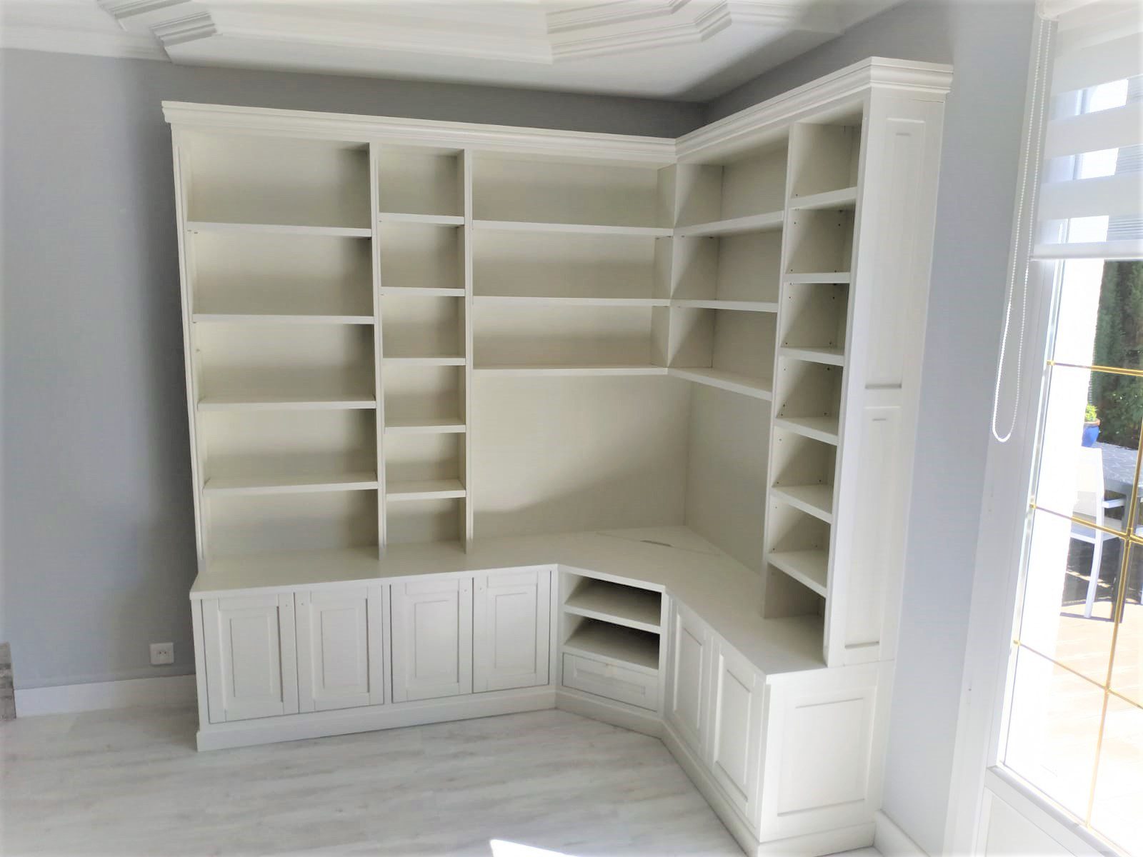 Jolie bibliothèque avec espace télé. En partie haute du meuble vous retrouvez des niches ouvertes, tandis qu'en partie basse ce sont des rangement avec porte.